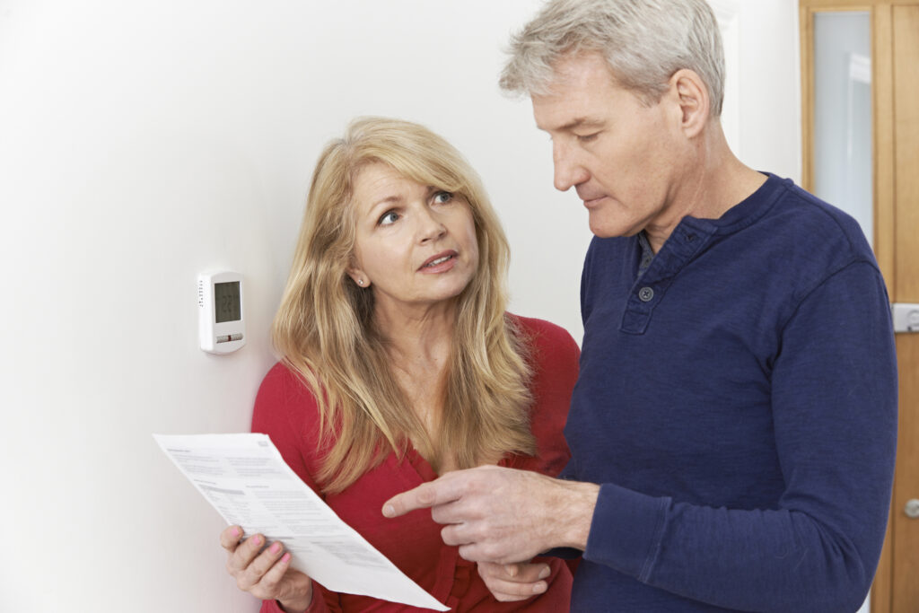 Worried Mature Couple With Bill Turning Down Central Cooling